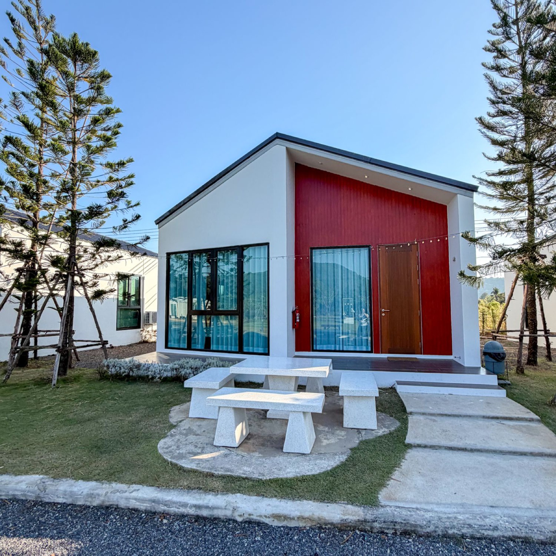 Two Bedroom Deluxe red-gabled house exterior with stone table